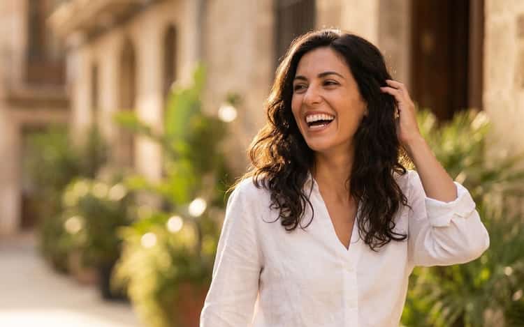 Mujer joven sonriendo con confianza mostrando dientes blancos y sanos tras su visita al Dentista en la Clínica de Benicalap, Valencia, Odéntitus.
